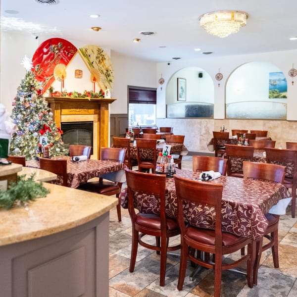 Dining room at Pho Vietnam with tables set, a decorated Christmas tree, and Vietnamese-inspired decor.